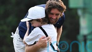 Tommy Fleetwood celebrates with son on 18th green after victory in Delhi