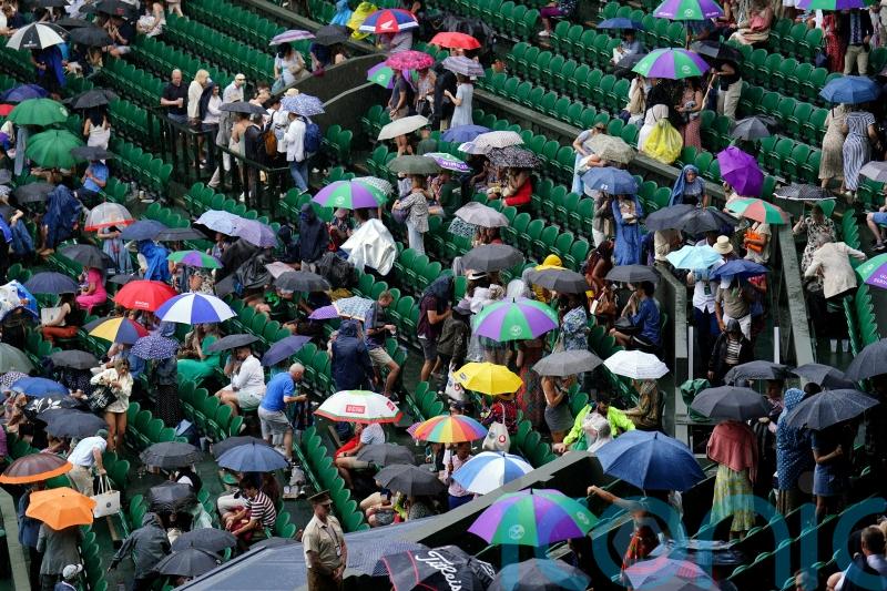 Tennis fans in macs and under umbrellas in queue for Wimbledon&rsquo;s middle Sunday