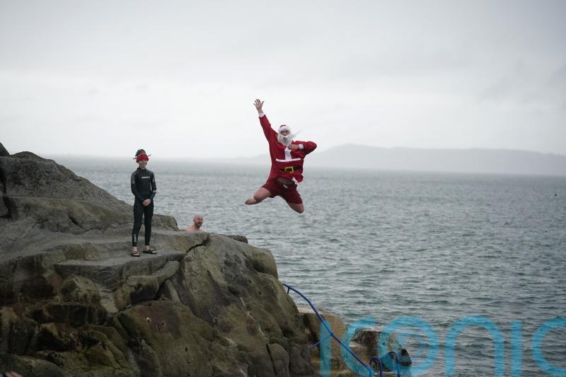 Crowds &ndash; including the &lsquo;Forty Foot Santa&rsquo; &ndash; take part in Christmas Day swim