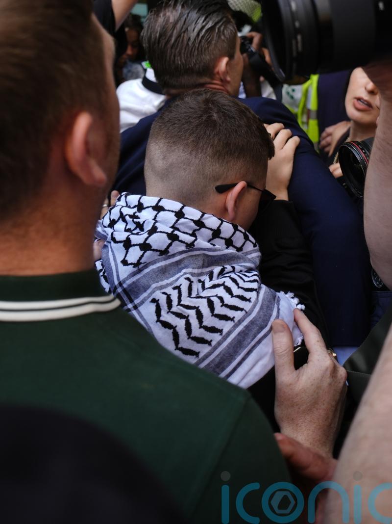 Kneecap greeted by hundreds at court as rap group member faces terrorism charge